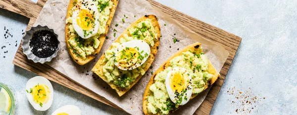 Mosade Avokado Och Kokta Ägg Toasts Med Gräslök Och Svarta Royaltyfria Stockbilder