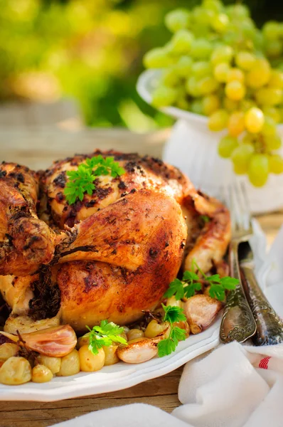 Целая жареная курица с виноградом, чесноком и миндалем — стоковое фото