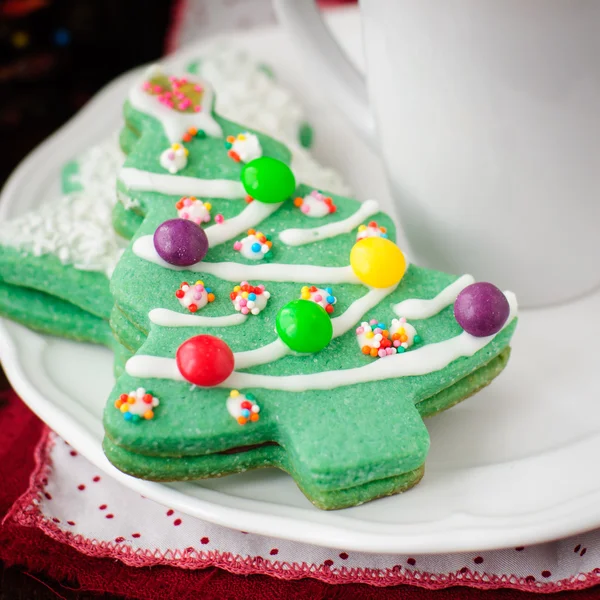 Bolinhos de árvore de Natal em uma placa branca com uma xícara de café — Fotografia de Stock