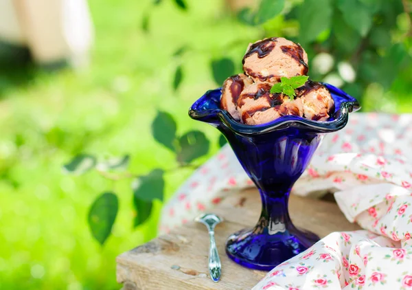 Шоколадное мороженое с фруктовым соусом в голубой миске Стоковая Картинка