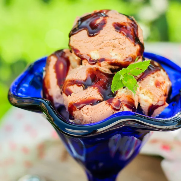Шоколадное мороженое с фруктовым соусом в голубой миске — стоковое фото