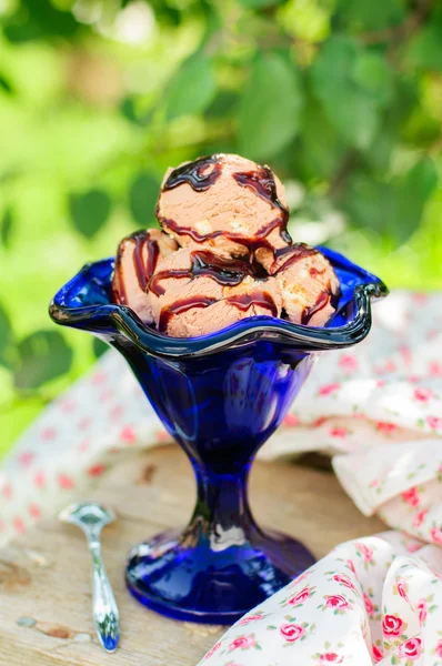 Sorvete de chocolate com molho de chocolate em uma tigela azul — Fotografia de Stock
