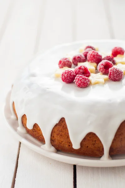 Banaan Cake met suiker glazuur gegarneerd met frambozen en banaan — Stockfoto