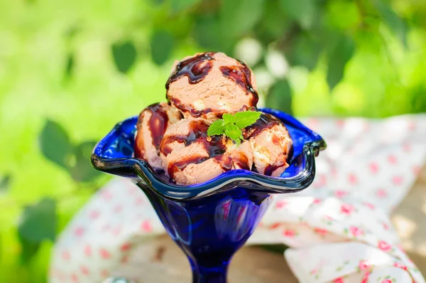 Gelato al cioccolato con salsa di cioccolato in una ciotola blu — Foto Stock