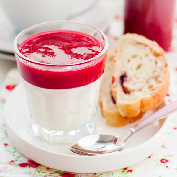 Греческий йогурт с ягодным соусом и ломтиками сладкого хлеба — стоковое фото