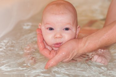 bir küvet içinde dalış öğrenen bir bebek