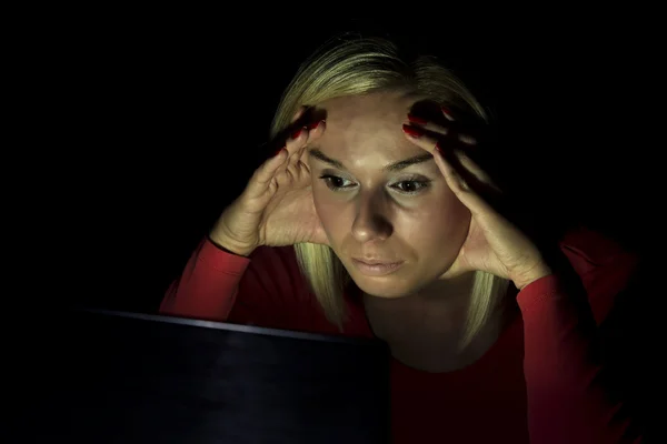 Vrouw kijken naar een computerscherm in het donker — Stockfoto