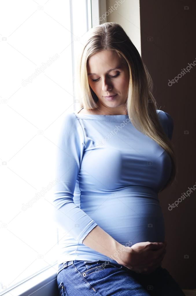 pregnant woman sitting by the window