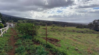 Güzel dağların ve bulutlu bir günde yeşil tepelerin dikey görüntüsü.