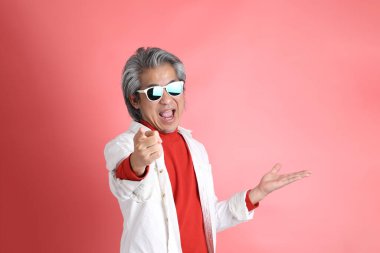 Pembe arka planda duran Asyalı adam..