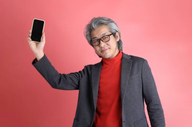 Pembe arka planda duran Asyalı adam..