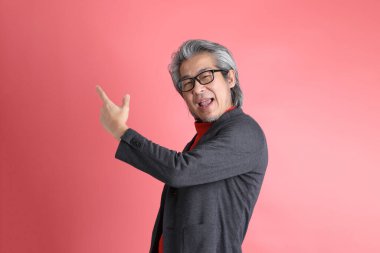 Pembe arka planda duran Asyalı adam..