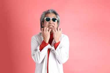 Pembe arka planda duran Asyalı adam..