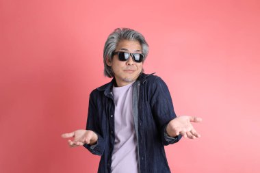 Pembe arka planda duran Asyalı adam..