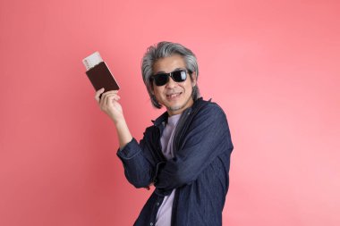 Pembe arka planda duran Asyalı adam..