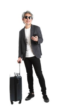 Beyaz arka planda bagajı olan kıdemli Asyalı işadamı..