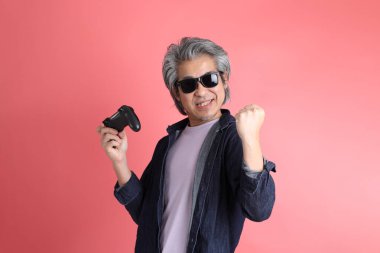 Pembe arka planda duran Asyalı adam..