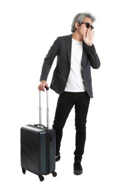 Beyaz arka planda bagajı olan kıdemli Asyalı işadamı..