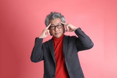 Pembe arka planda duran Asyalı adam..