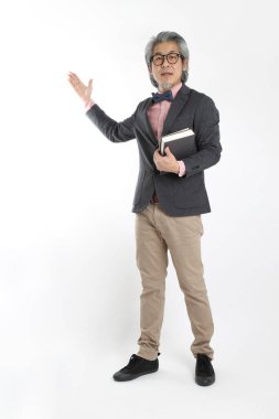 Beyaz arka planda duran kıdemli Asyalı öğretmen..