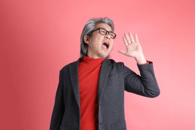 Pembe arka planda duran Asyalı adam..