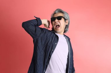 Pembe arka planda duran Asyalı adam..