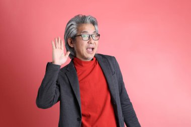 Pembe arka planda duran Asyalı adam..