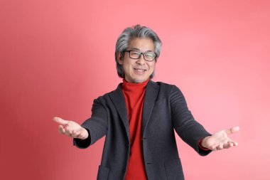 Pembe arka planda duran Asyalı adam..