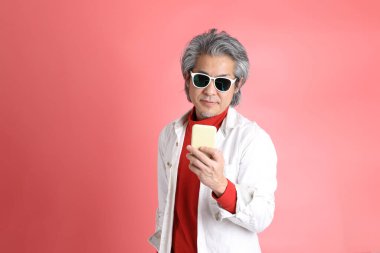 Pembe arka planda duran Asyalı adam..