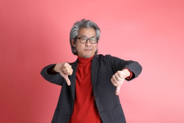 Pembe arka planda duran Asyalı adam..