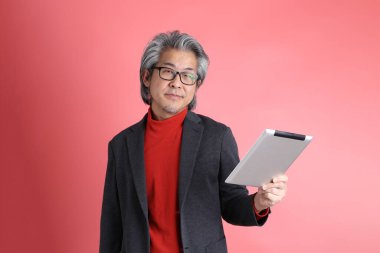 Pembe arka planda duran Asyalı adam..