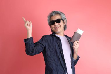 Pembe arka planda duran Asyalı adam..