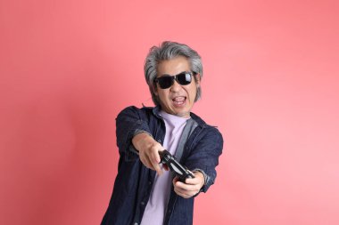 Pembe arka planda duran Asyalı adam..