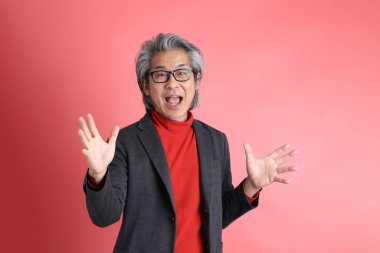 Pembe arka planda duran Asyalı adam..