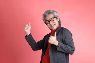 Pembe arka planda duran Asyalı adam..