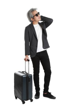 Beyaz arka planda bagajı olan kıdemli Asyalı işadamı..