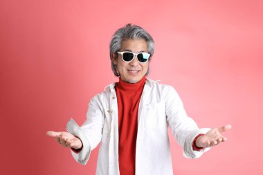 Pembe arka planda duran Asyalı adam..