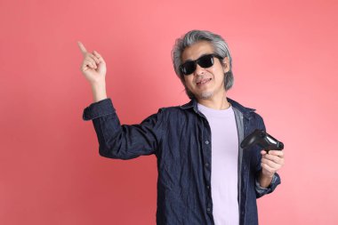 Pembe arka planda duran Asyalı adam..