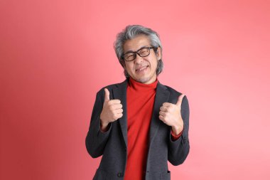 Pembe arka planda duran Asyalı adam..