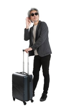 Beyaz arka planda bagajı olan kıdemli Asyalı işadamı..