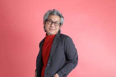 Pembe arka planda duran Asyalı adam..