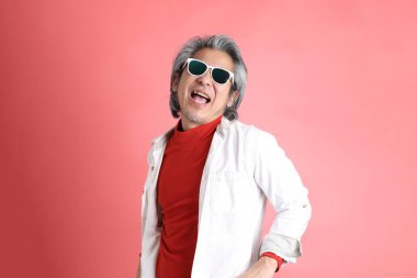 Pembe arka planda duran Asyalı adam..