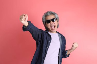 Pembe arka planda duran Asyalı adam..