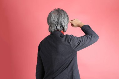 Pembe arka planda duran Asyalı adam..