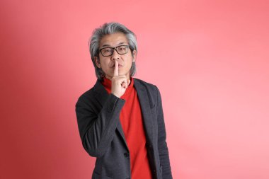 Pembe arka planda duran Asyalı adam..