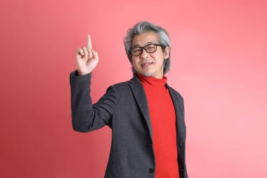 Pembe arka planda duran Asyalı adam..