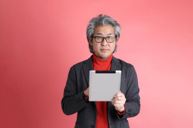 Pembe arka planda duran Asyalı adam..