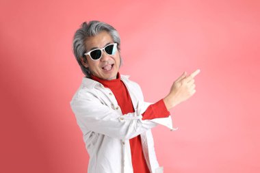 Pembe arka planda duran Asyalı adam..