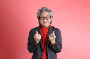 Pembe arka planda duran Asyalı adam..