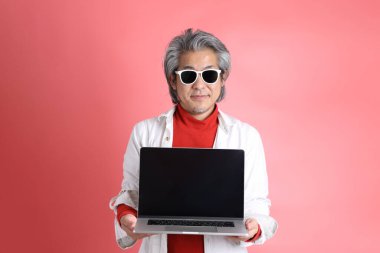 Pembe arka planda duran Asyalı adam..